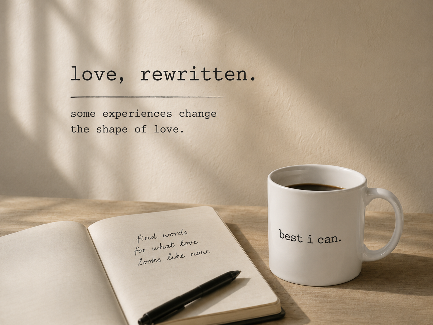 A white mug with black text saying 'best i can.', a black pen, an open notebook with handwritten words 'find words for what love looks like now,' and a wall with the words 'love, rewritten. some experiences change the shape of love.' written on it, all on a wooden surface with sunlight and shadows.