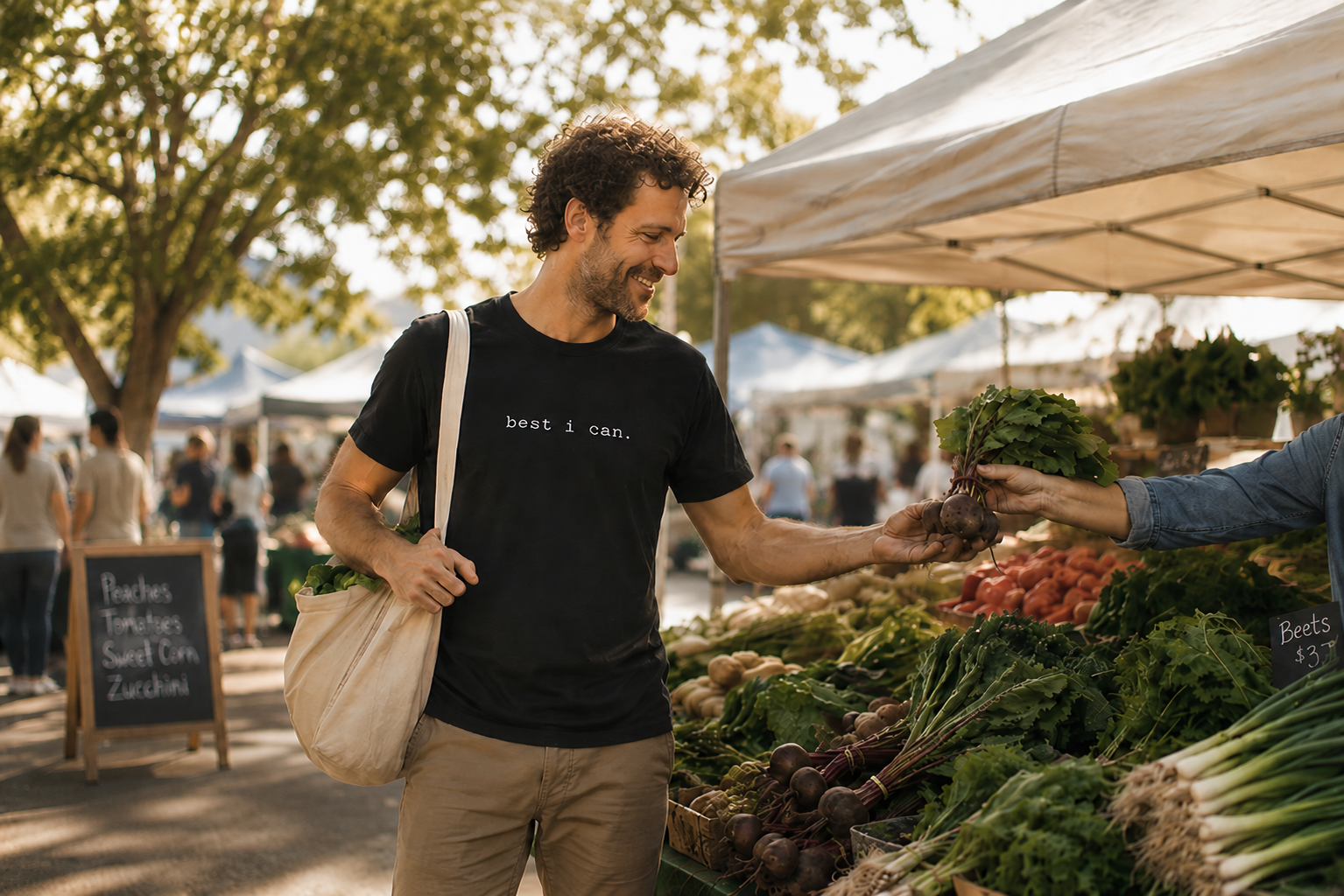 person wearing a black best i can t-shirt while shopping at a local farmers market