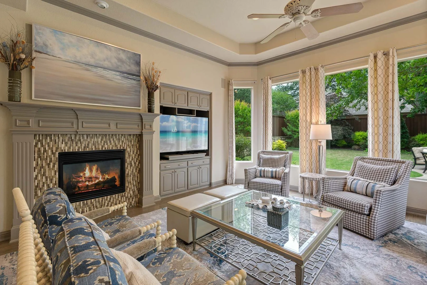 Living room with a fireplace, armchairs and large curtained windows