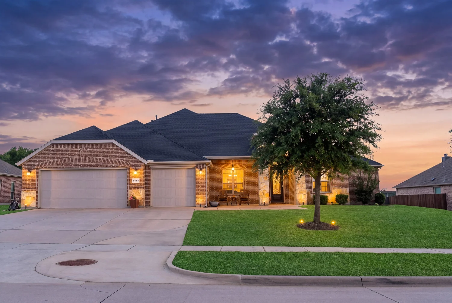 Digital twilight real estate exterior with illuminated windows and an evening sky