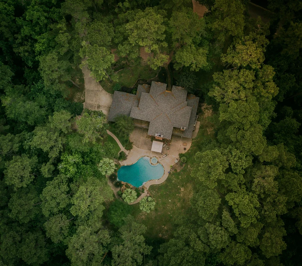 Aerial view of a large home surrounded by mature trees