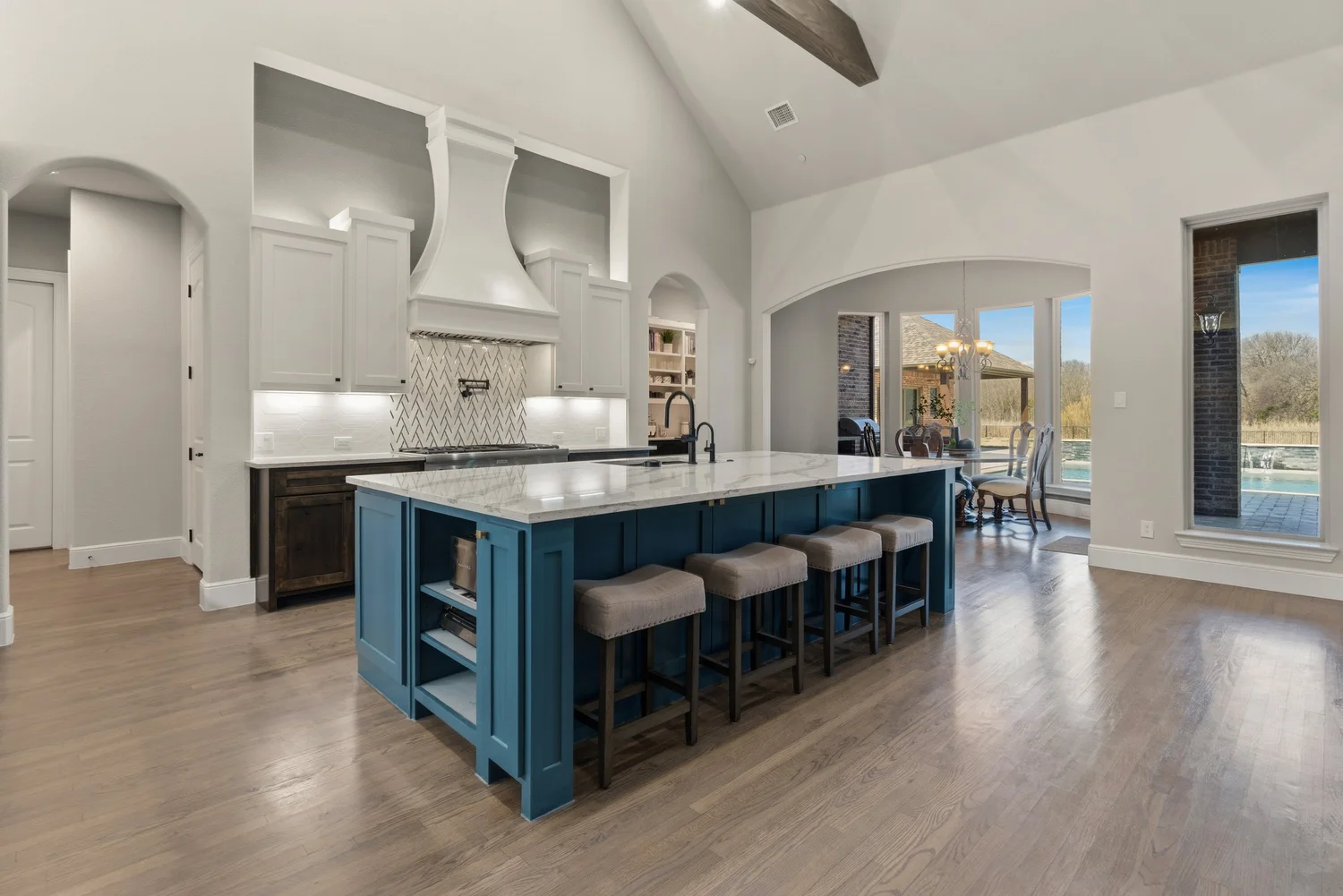 Blue kitchen island and open-concept interior photographed for a listing