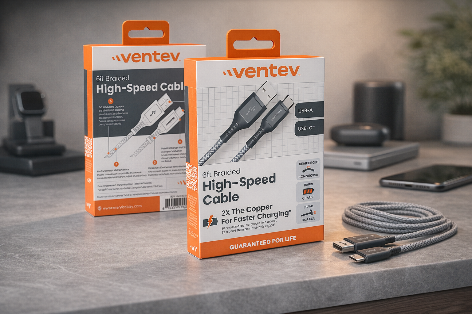 Two boxes of Ventev 6-foot braided high-speed USB cables, with one cable displayed outside the box showing its gray braided design and USB-A and USB-C connectors, placed on a gray tabletop with electronic devices and a smartphone in the background.