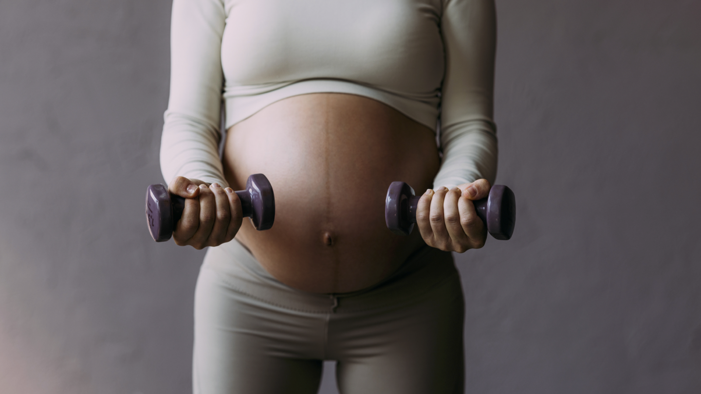 pregnant woman working out with dumbbells