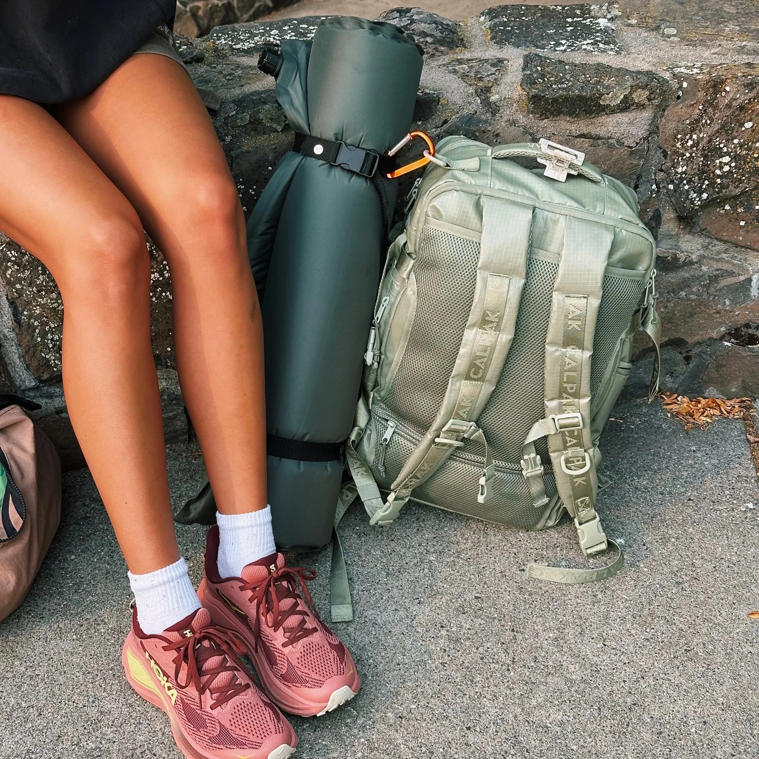 Woman's legs, hiking shoes, backpack and mat