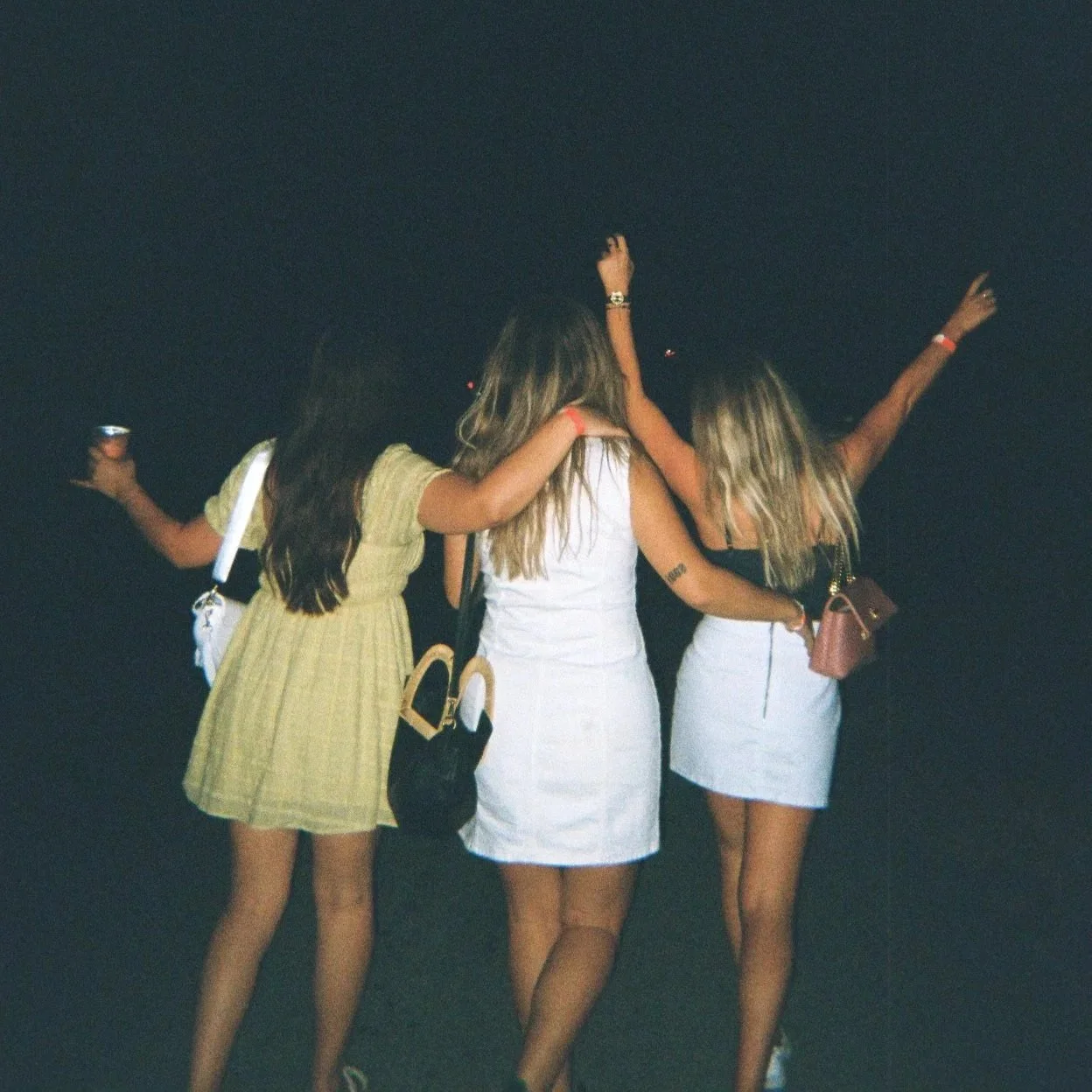 Three women hugging, walking and dancing during the night