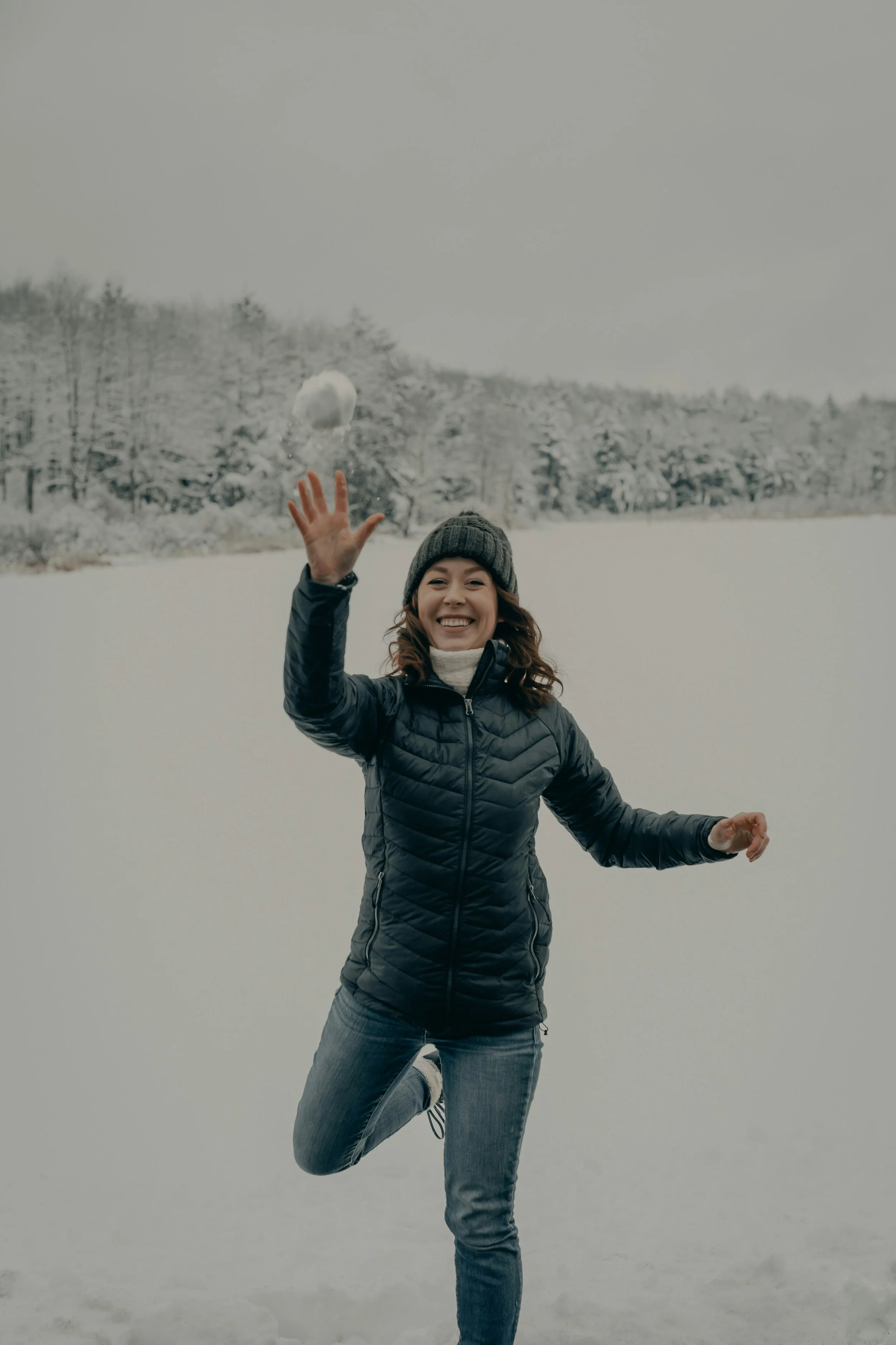 Woman jumping joyfully and playing with the snow