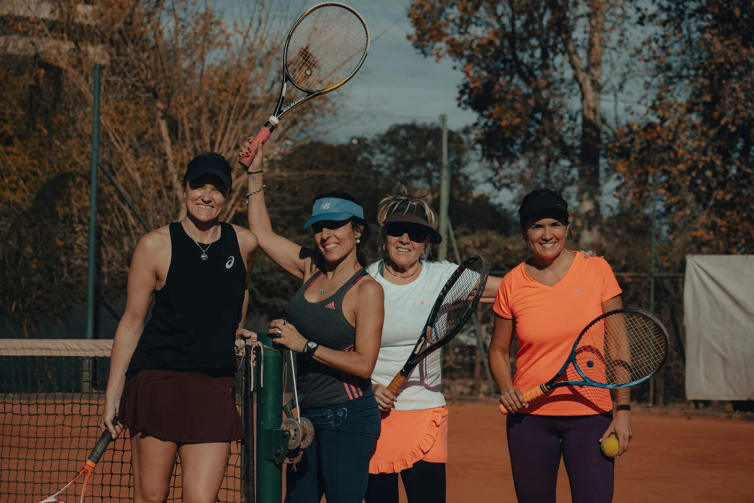 Four women playing tennis