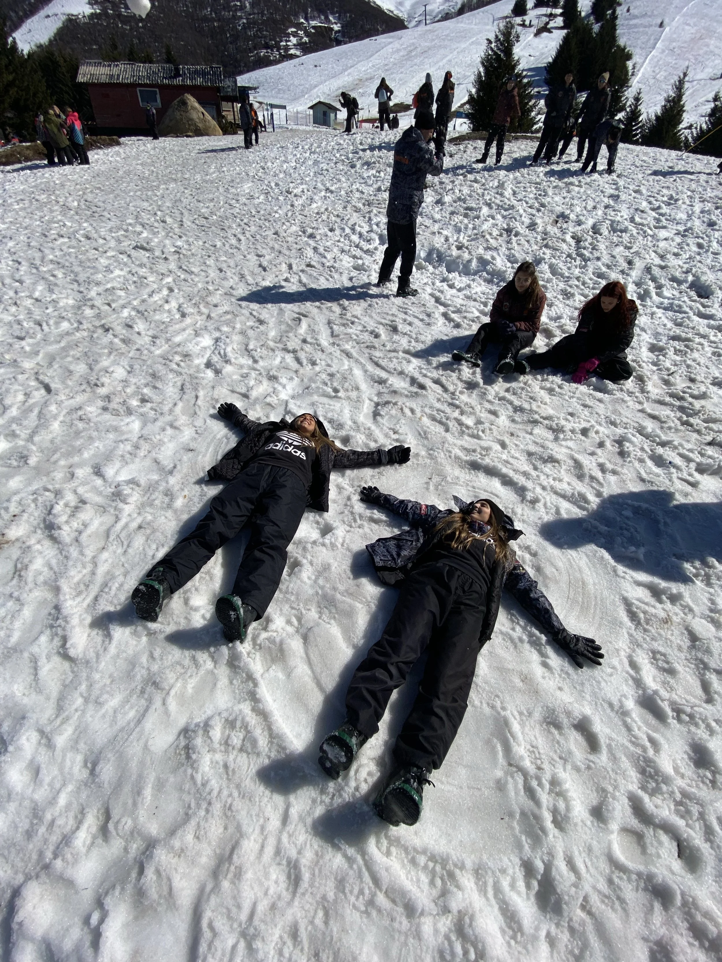 Two women laying and palying on the snow