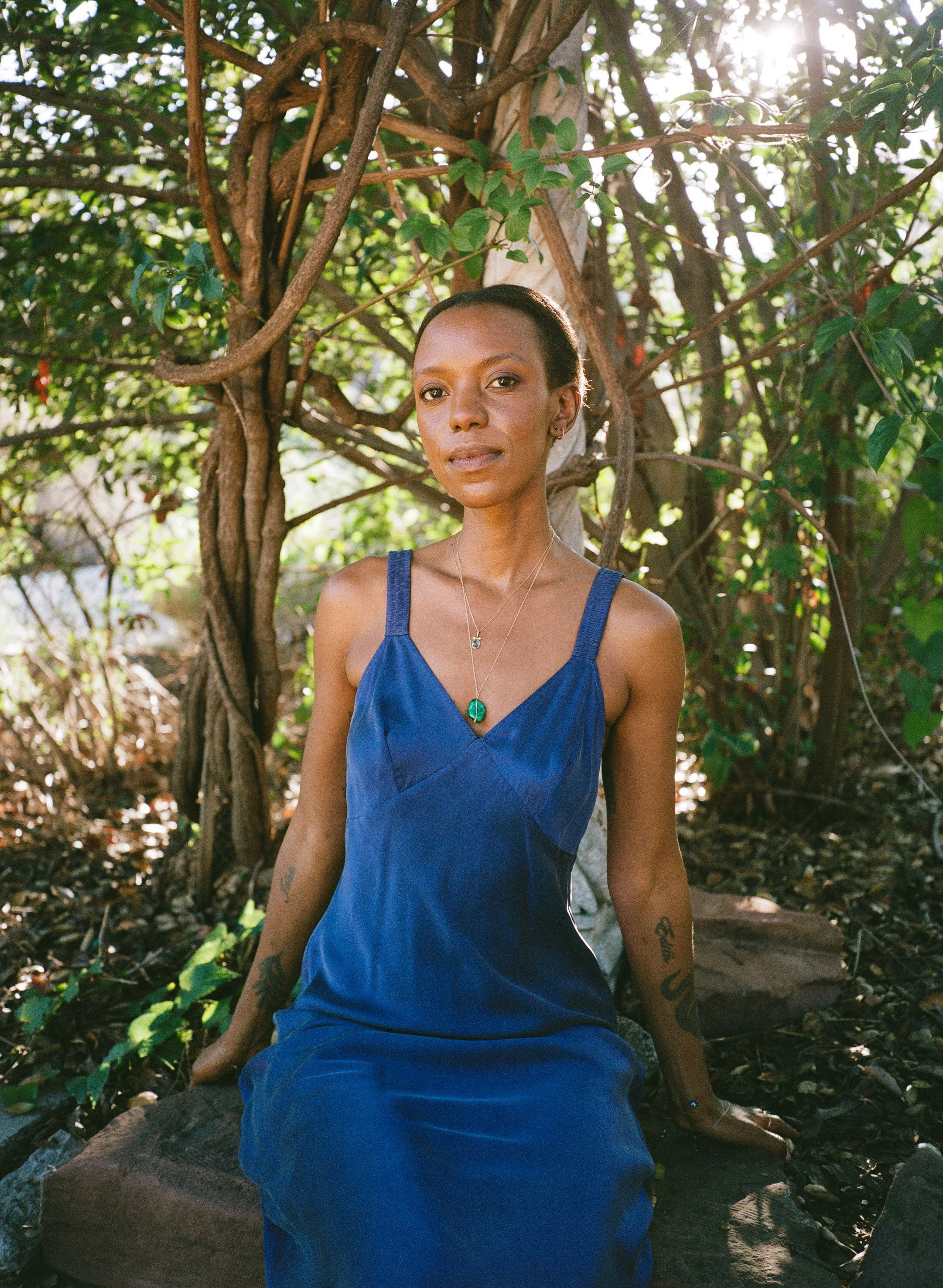 Wandie Kabule, a Certified Level III Reiki Master, sitting in a serene nature setting.