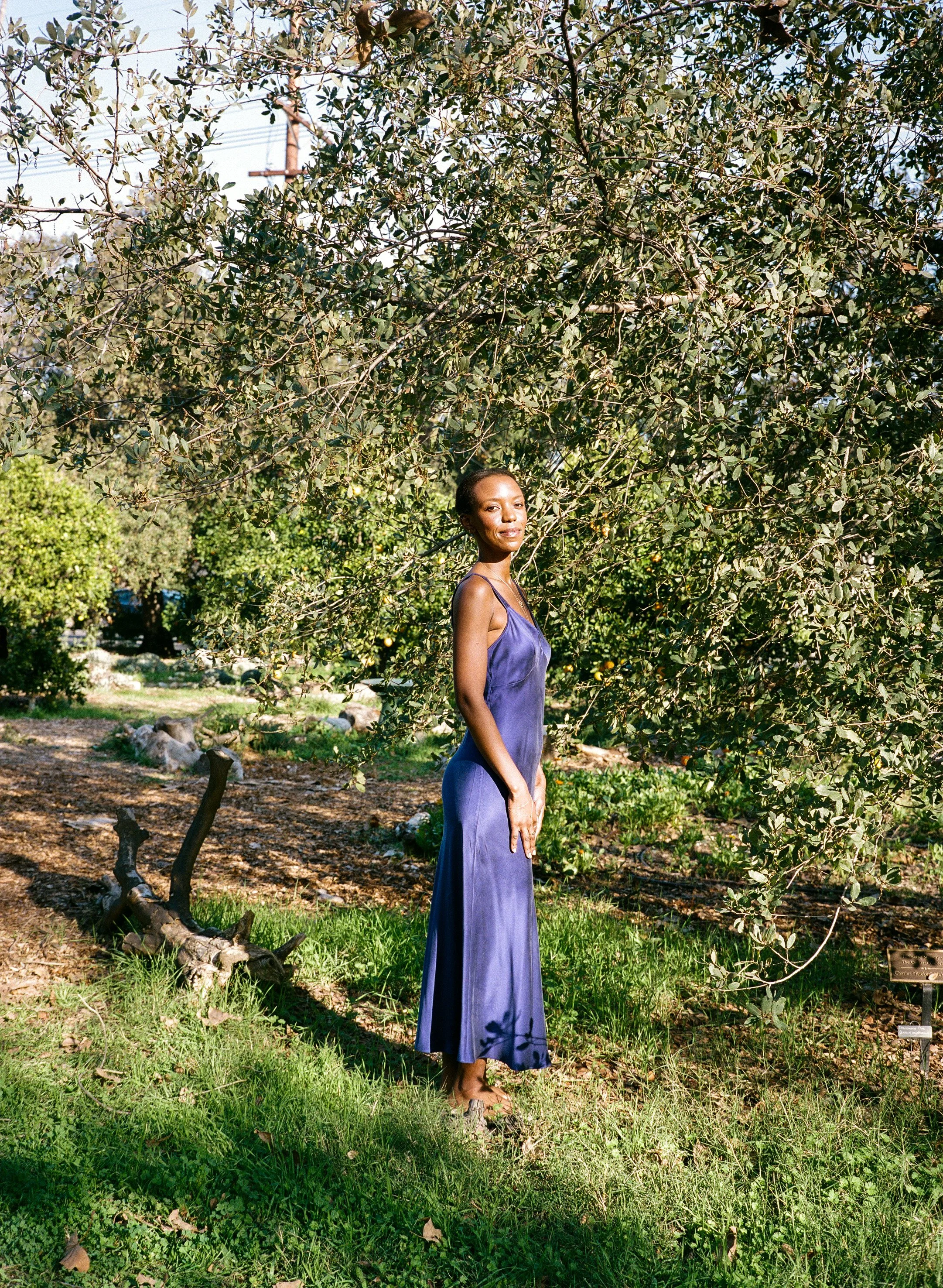 Wandie Kabule, a Certified Level III Reiki Master, standing in a serene nature setting.