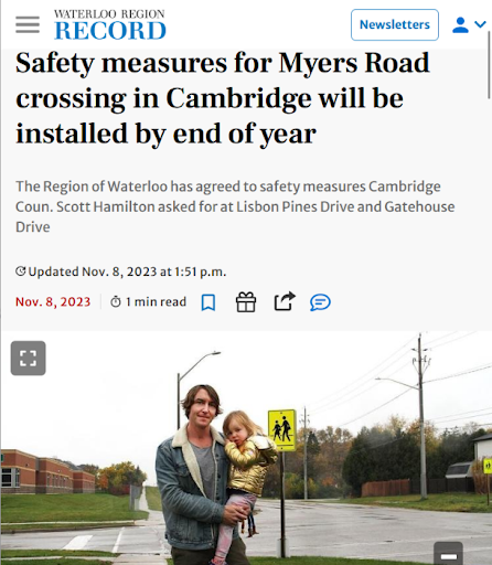 Screenshot of a news article about safety measures for Myers Road crossing in Cambridge, including a photo of a man holding a young girl on a street corner near pedestrian crossing signs.