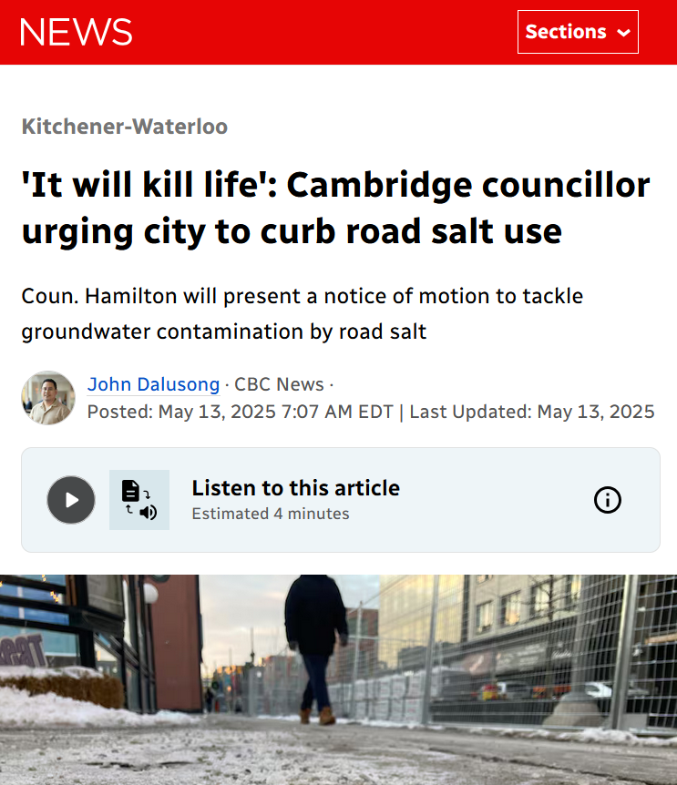 A person walking on a snowy sidewalk near a building with a fence and parked cars in the background, as seen in a news website article.