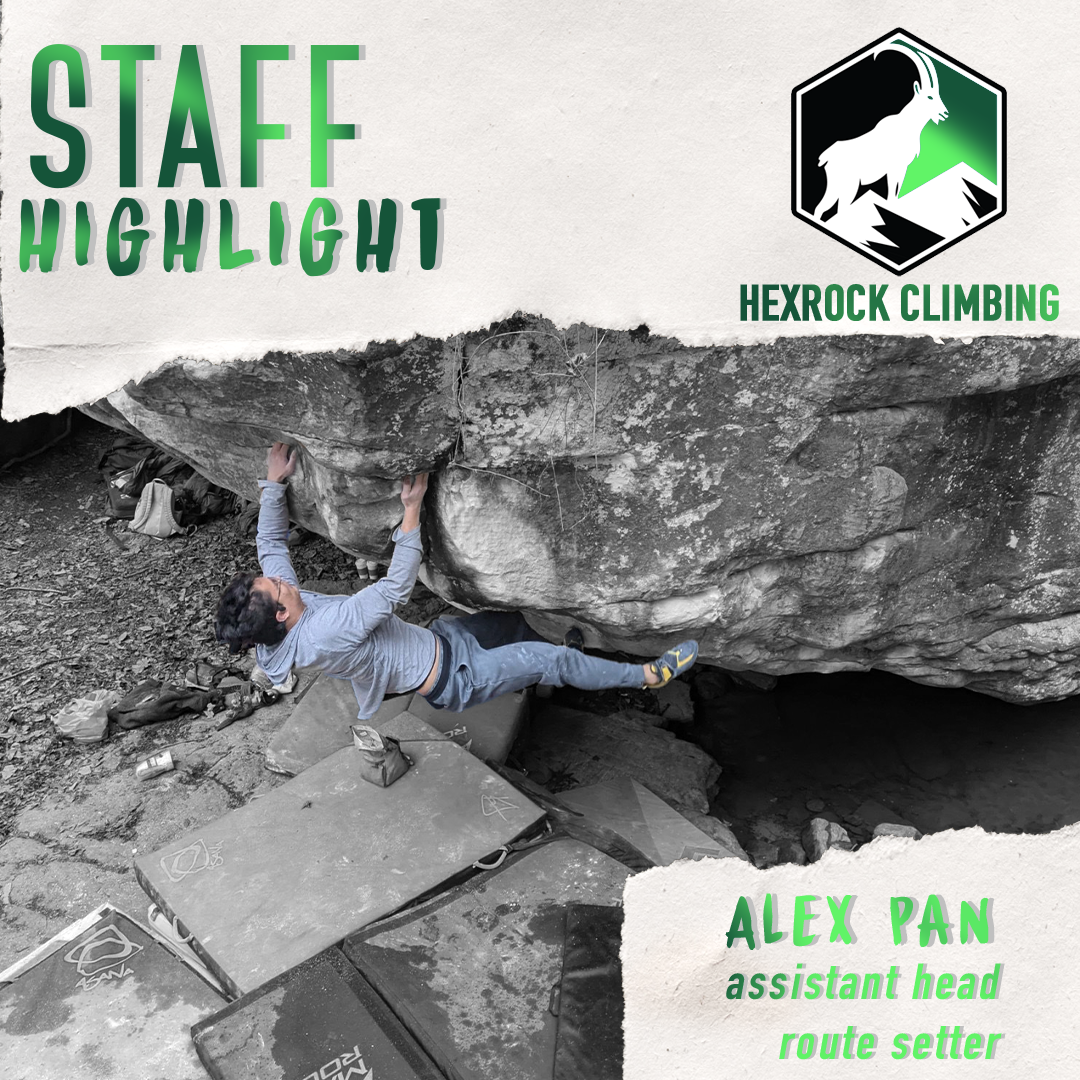 A person bouldering on a large rock, with climbing gear and crash pads on the ground below, indicating an indoor or outdoor climbing setting.