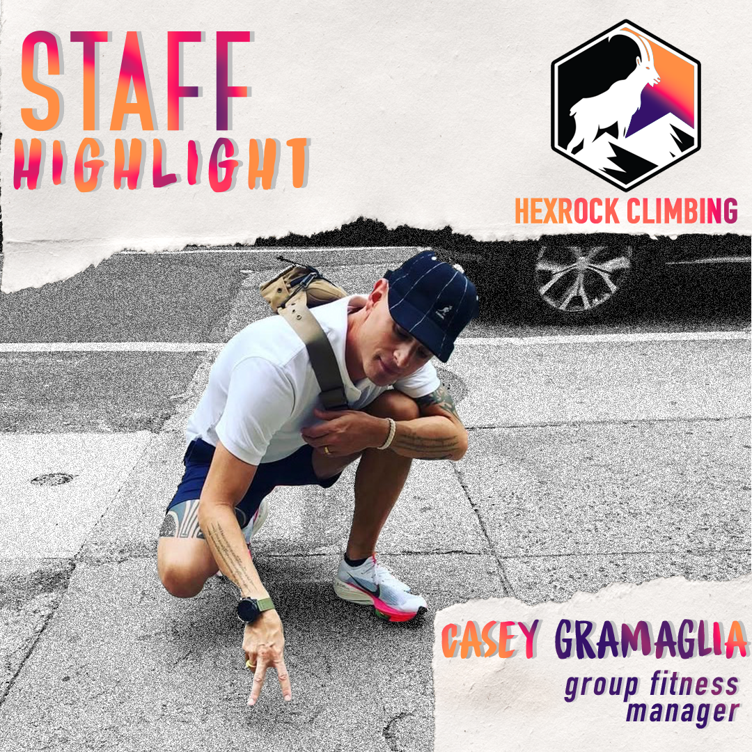 A person crouching on a sidewalk, pointing downward with a peace sign. The image features text about a staff highlight for Hexrock Climbing, with the name Casey Gramaglia, a group fitness manager, and a mountain goat logo.
