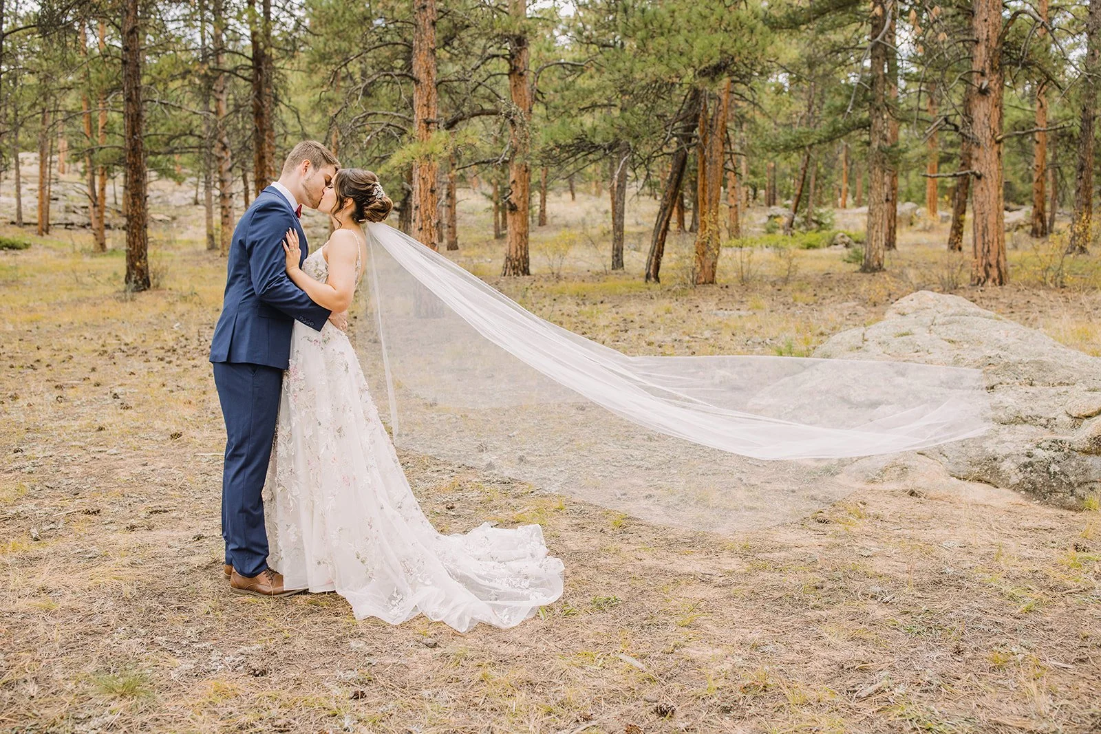 Elegant Colorado Springs wedding reception with ivory and red florals and mountain views