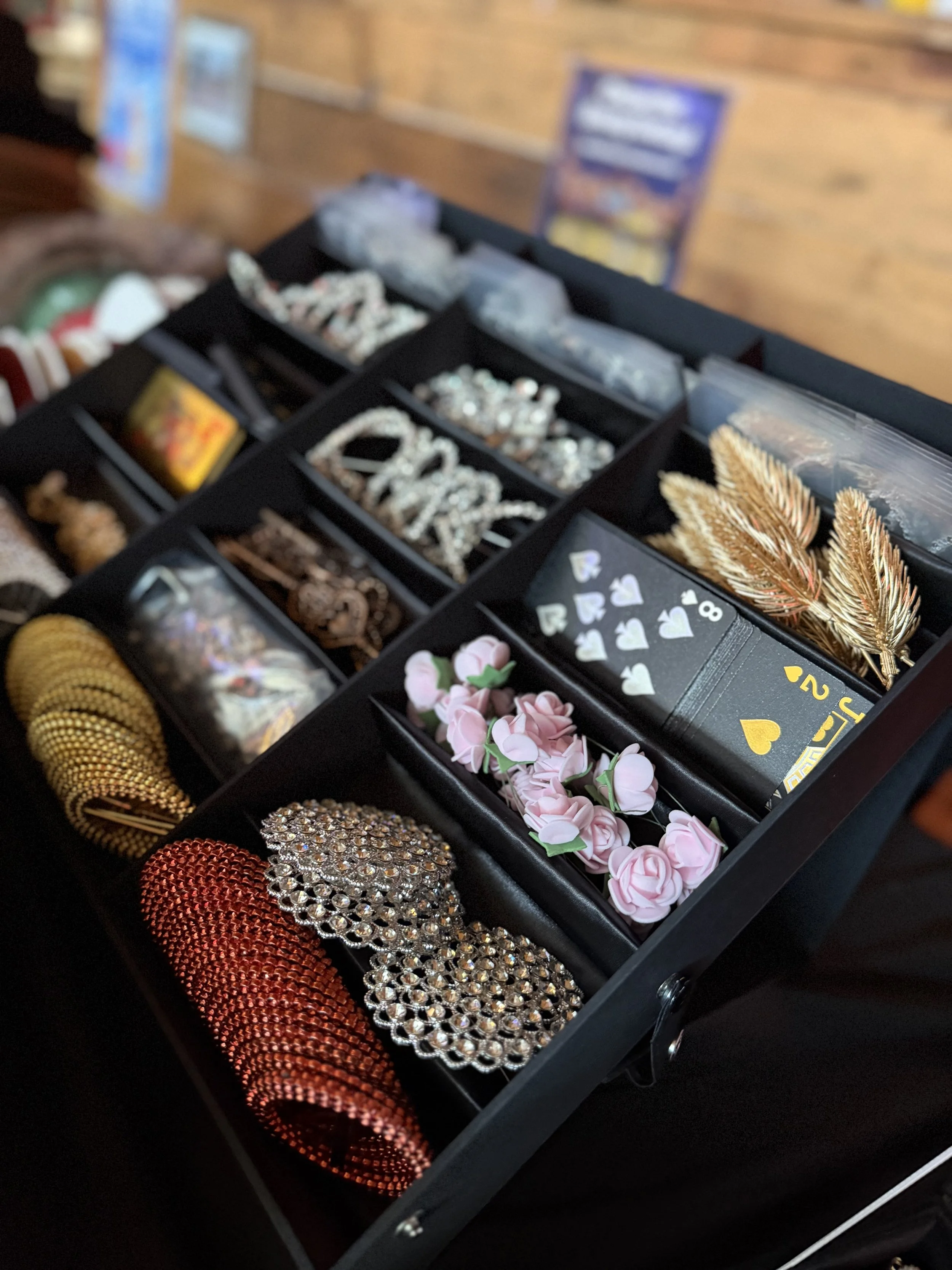 A display case filled with jewelry and accessories, including bracelets, earrings, brooches, and decorative hairpieces, in various colors and styles.