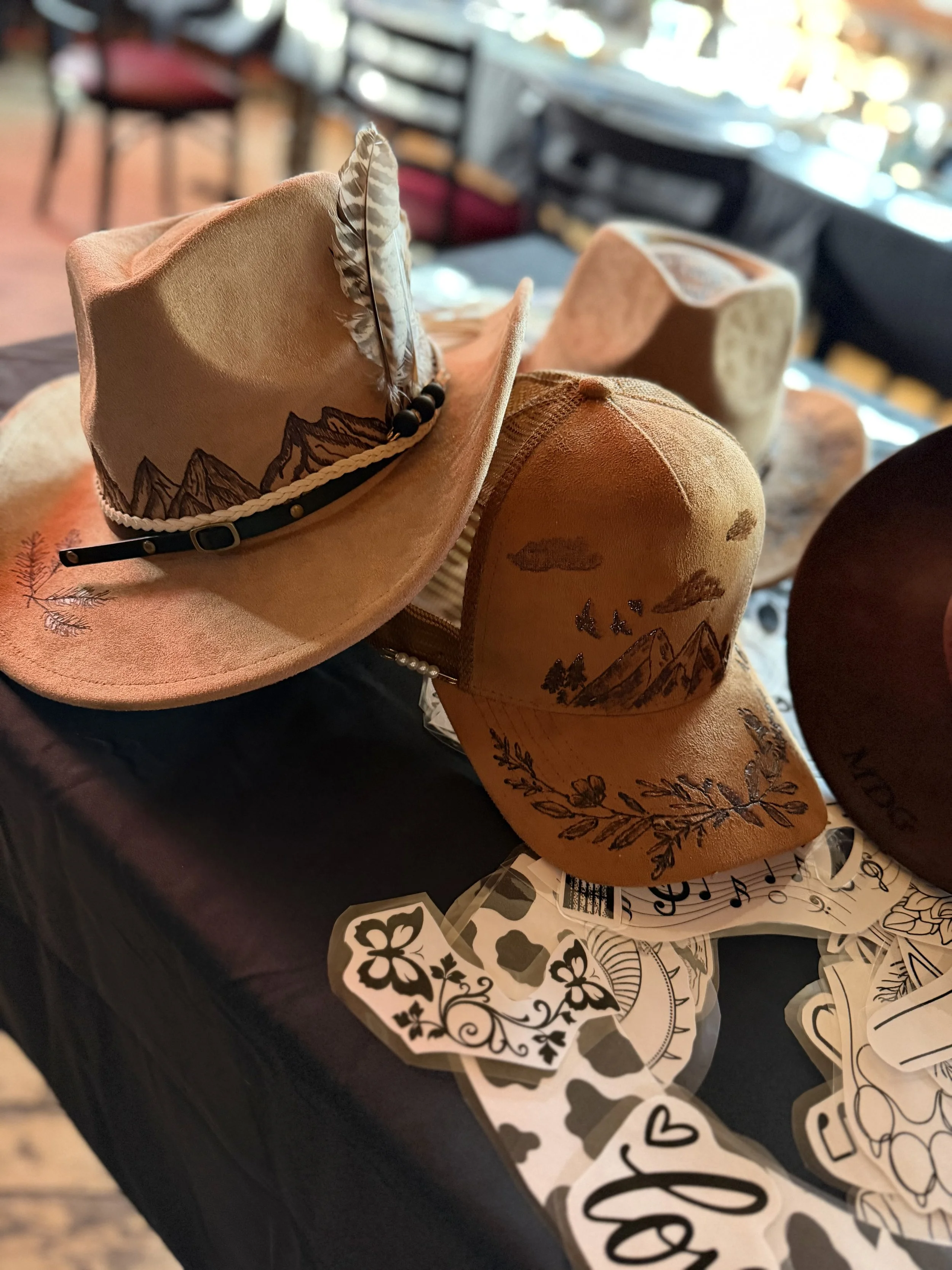 A collection of cowboy hats and decorative stickers on a table inside a restaurant.