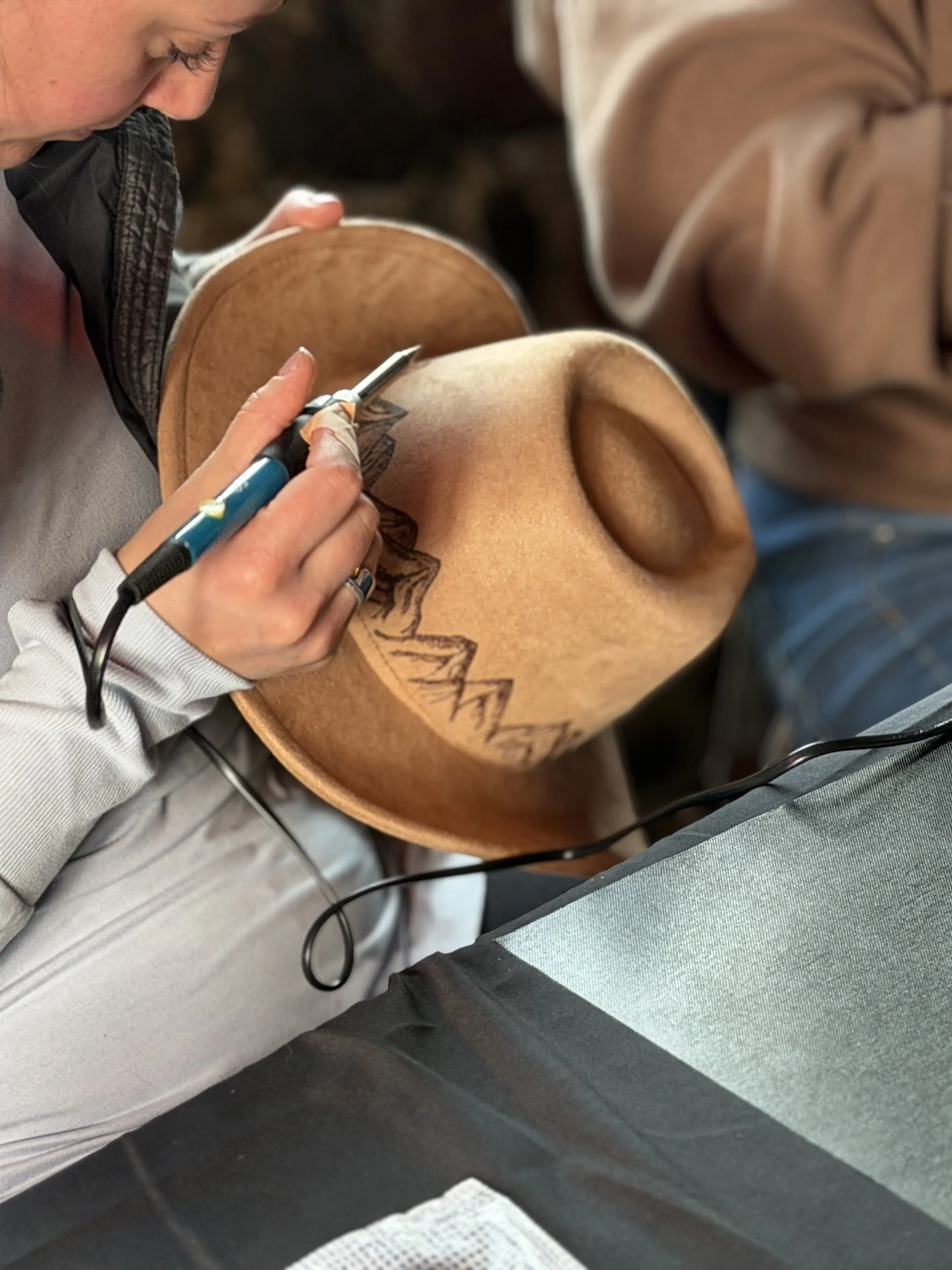 A person is creating a tattoo on a person's skin using a tattoo machine.
