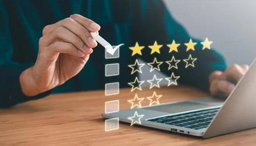 Person rating a star review checklist on a laptop and holding a checkmark marker.