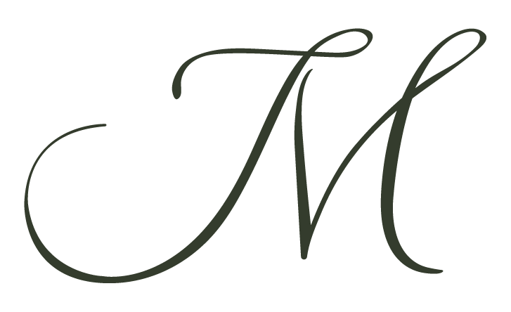Elegant black cursive letter M on white background.