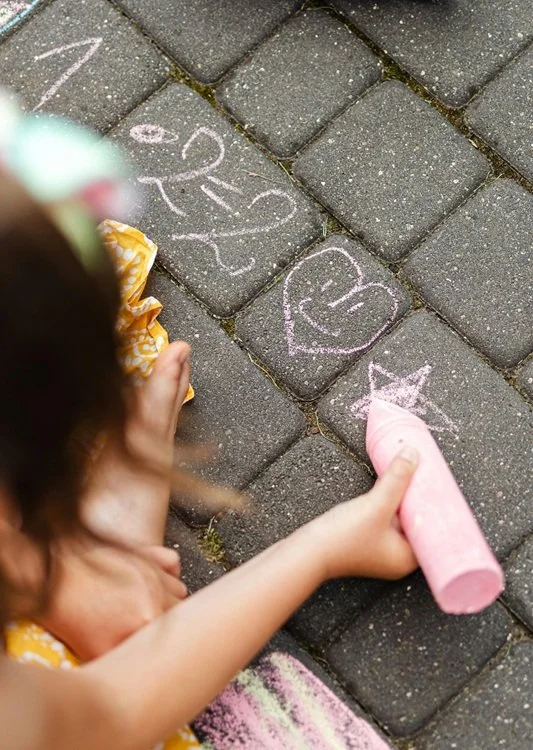 Girl solving math problem with chalk