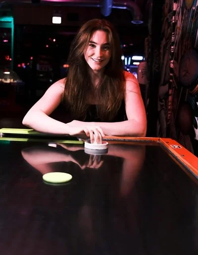 Girl sitting by air hockey table