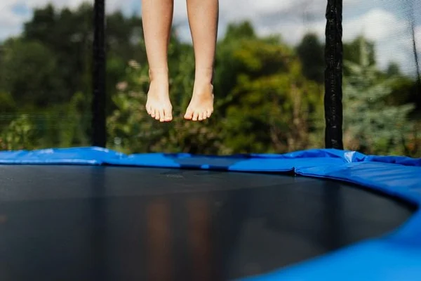 Child's feet jumping on a trampoline
