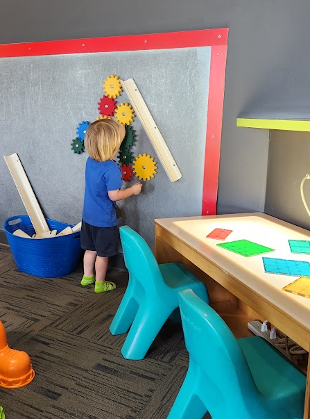 Toddler exploring gravity and gears at children's museum