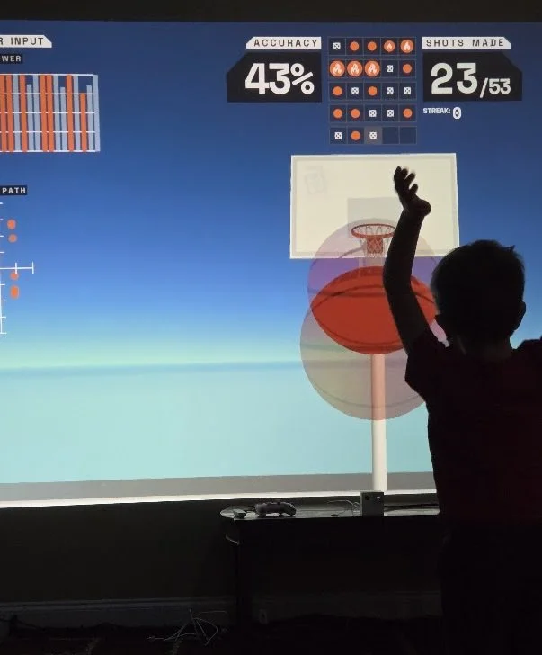 Boy plays interactive virtual basketball.