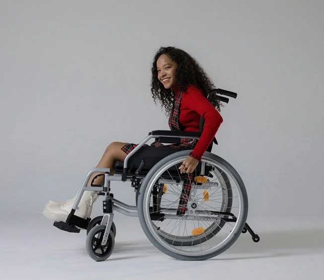 Teenage girl in wheelchair smiling.