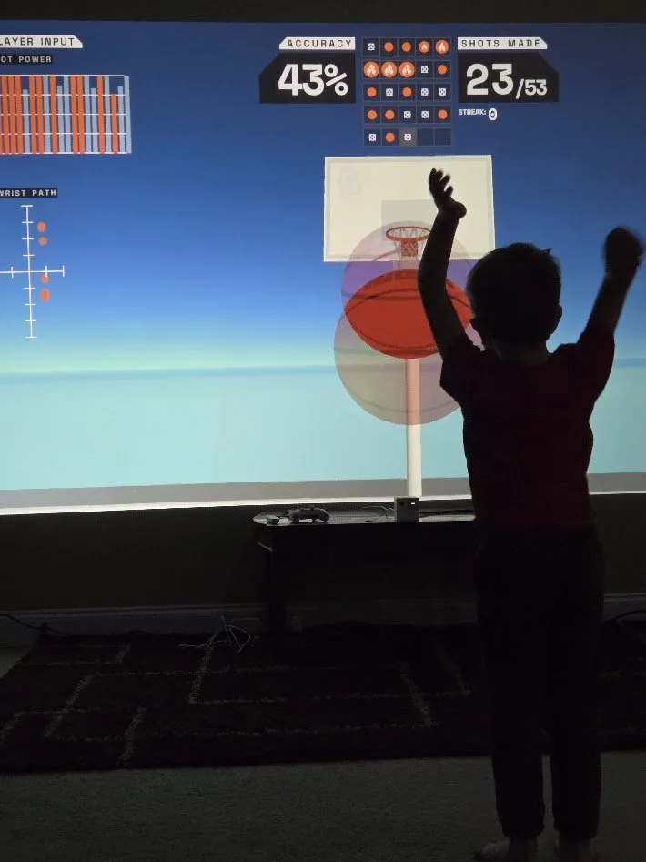 Boy playing interactive basketball game