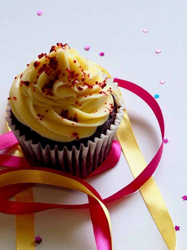 Cupcake with pink and yellow ribbon underneath