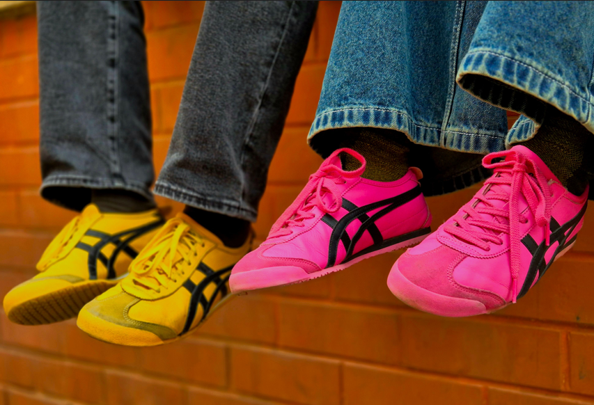 Two people wearing yellow and pink sneakers.