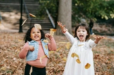Two girls playing in leaves