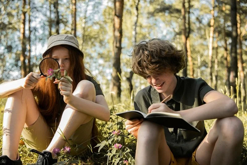 2 teenagers sitting and exploring nature