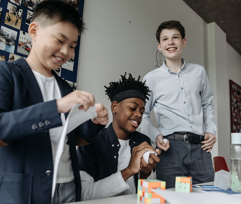 3 boys making things at table