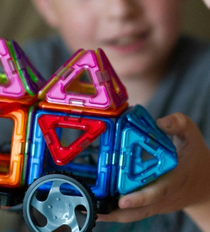 Boy showing his magnetic tiles creation