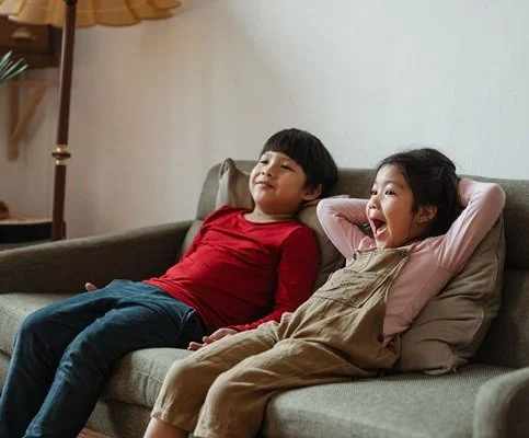 2 kids on couch watching TV