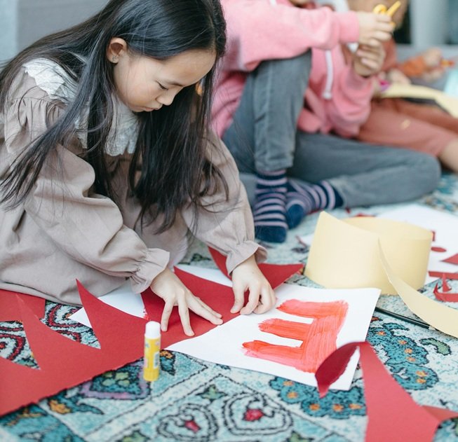 Kids sitting on floor doing art.
