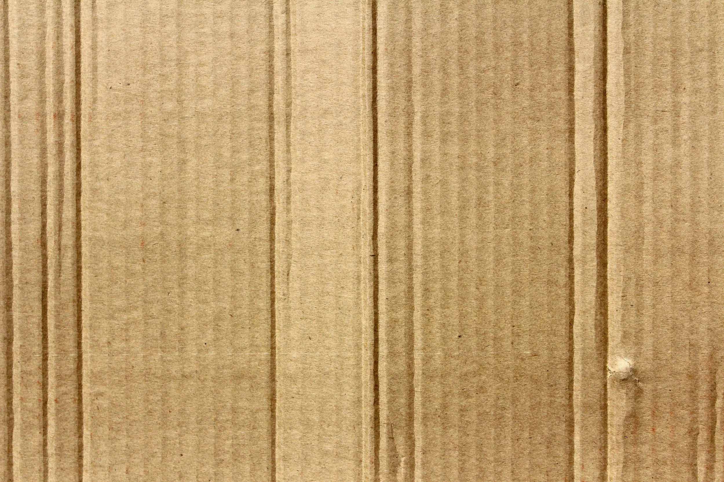 Close-up of a light brown wooden surface with visible grain and vertical lines.