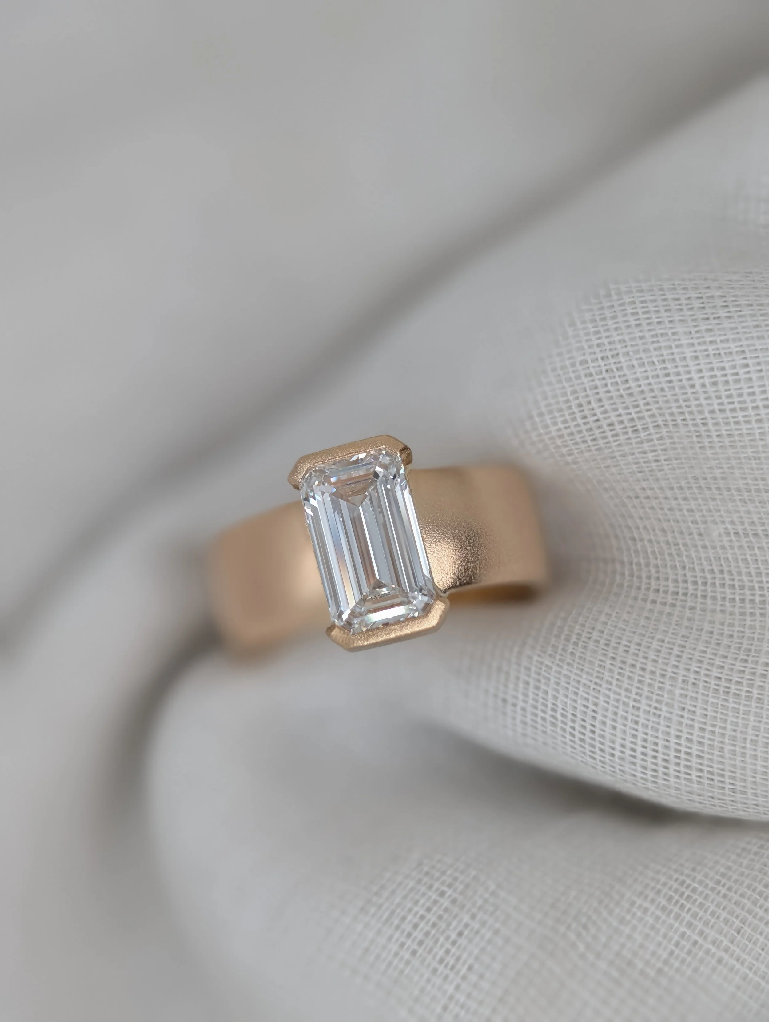 EMERALD-CUT SOLITARE DIAMOND WITH BEZEL SETTING