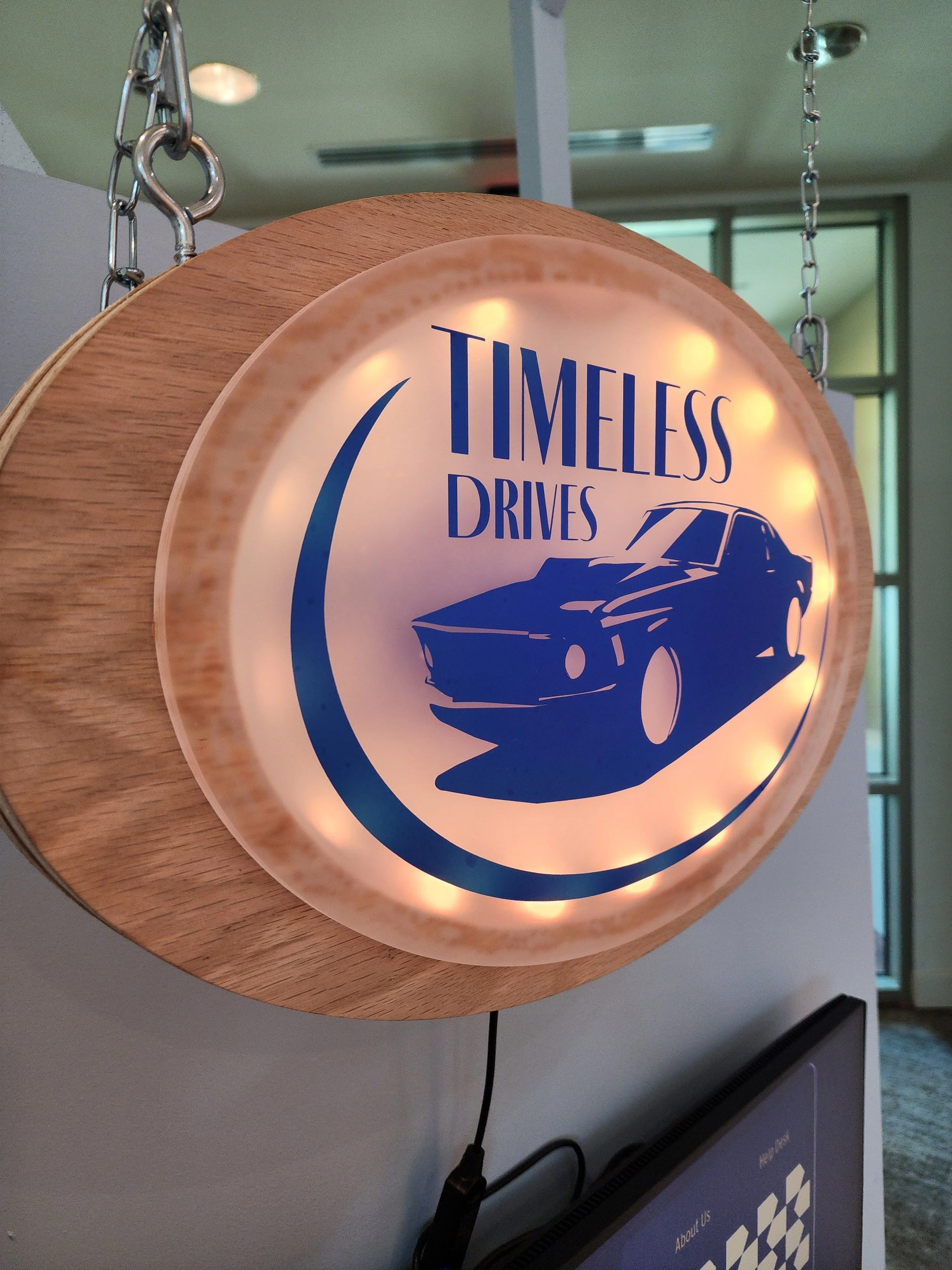 Hanging light-up sign with car logo on front