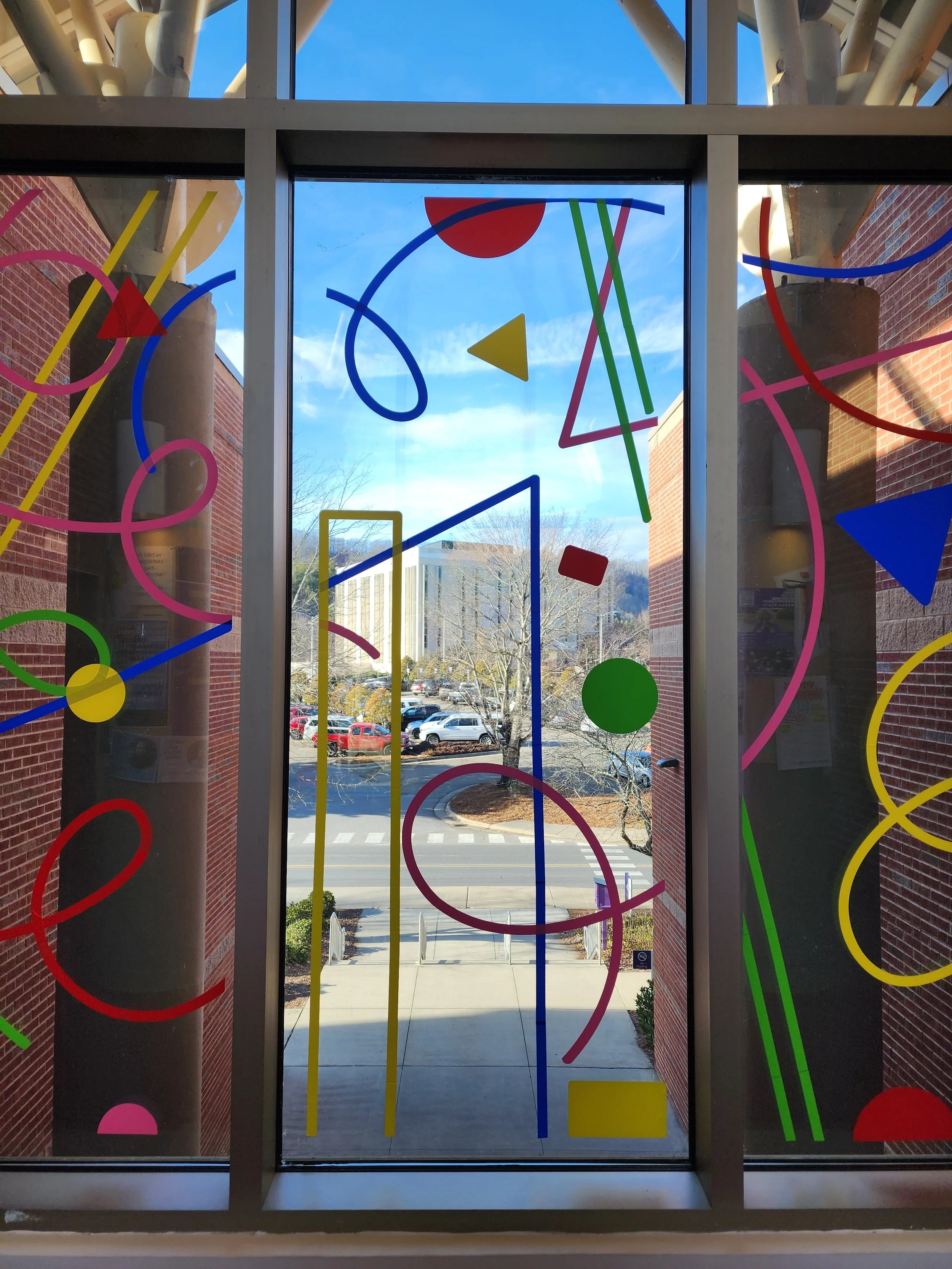 Color vinyl overlaps and swoops in circular patterns across a window