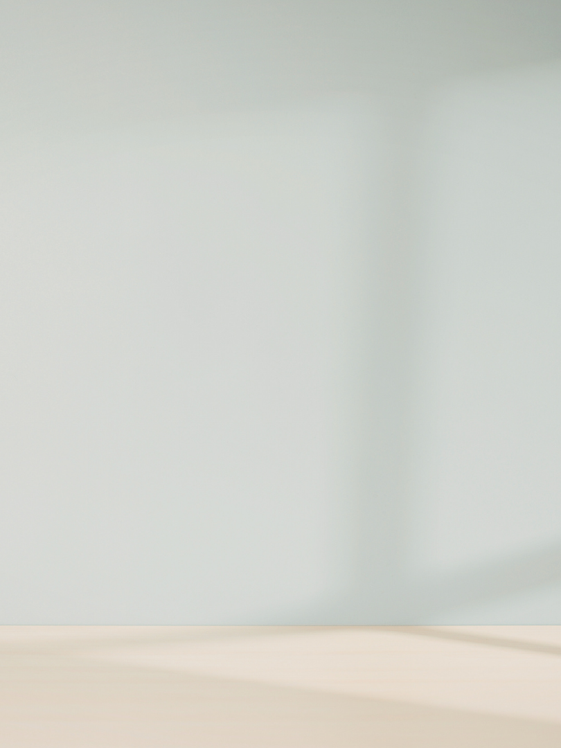 Empty white wall with shadows cast on the lower right corner.