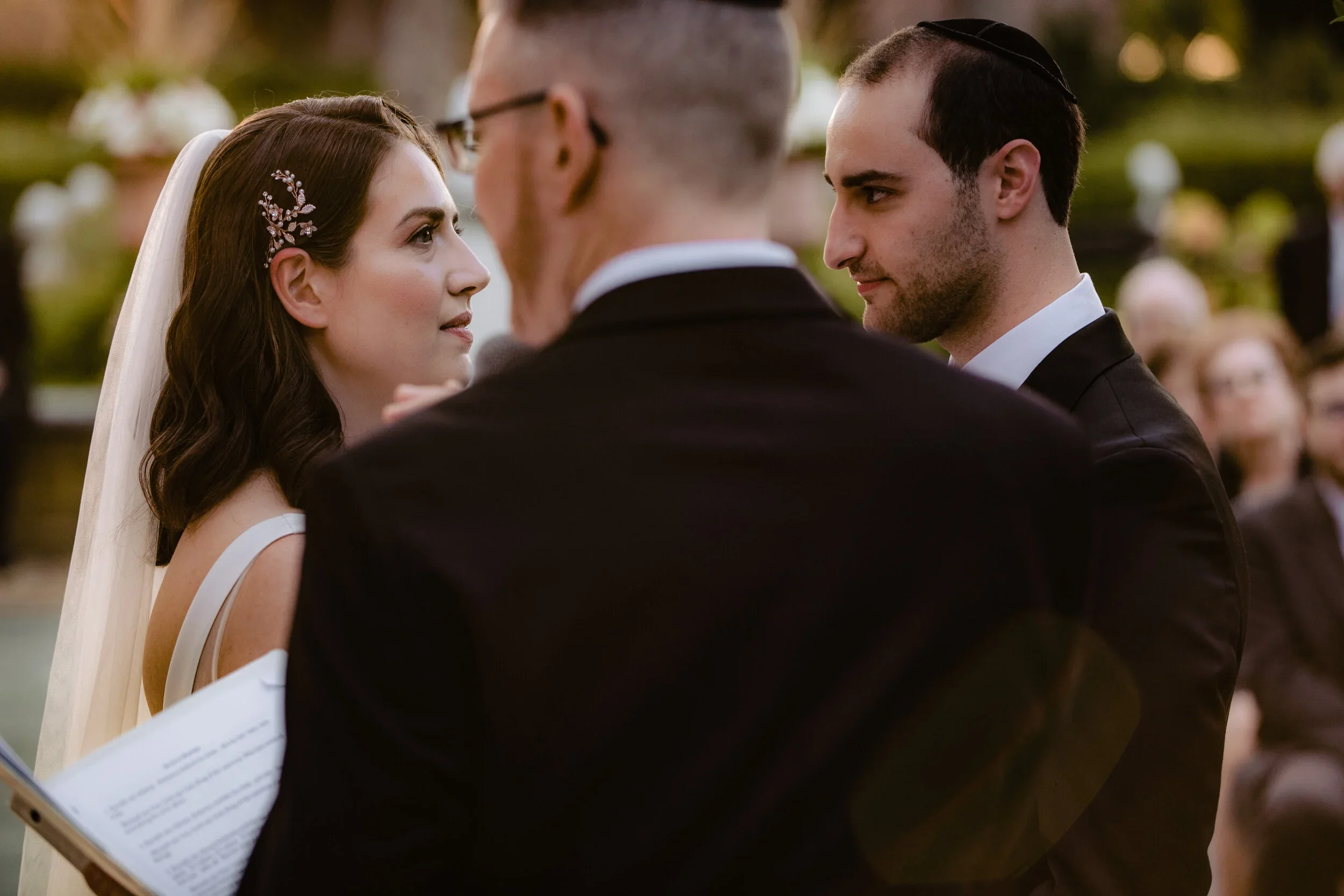 Laurie’s customers, Mariana and Carmen holding hands on a green lawn on their wedding day.