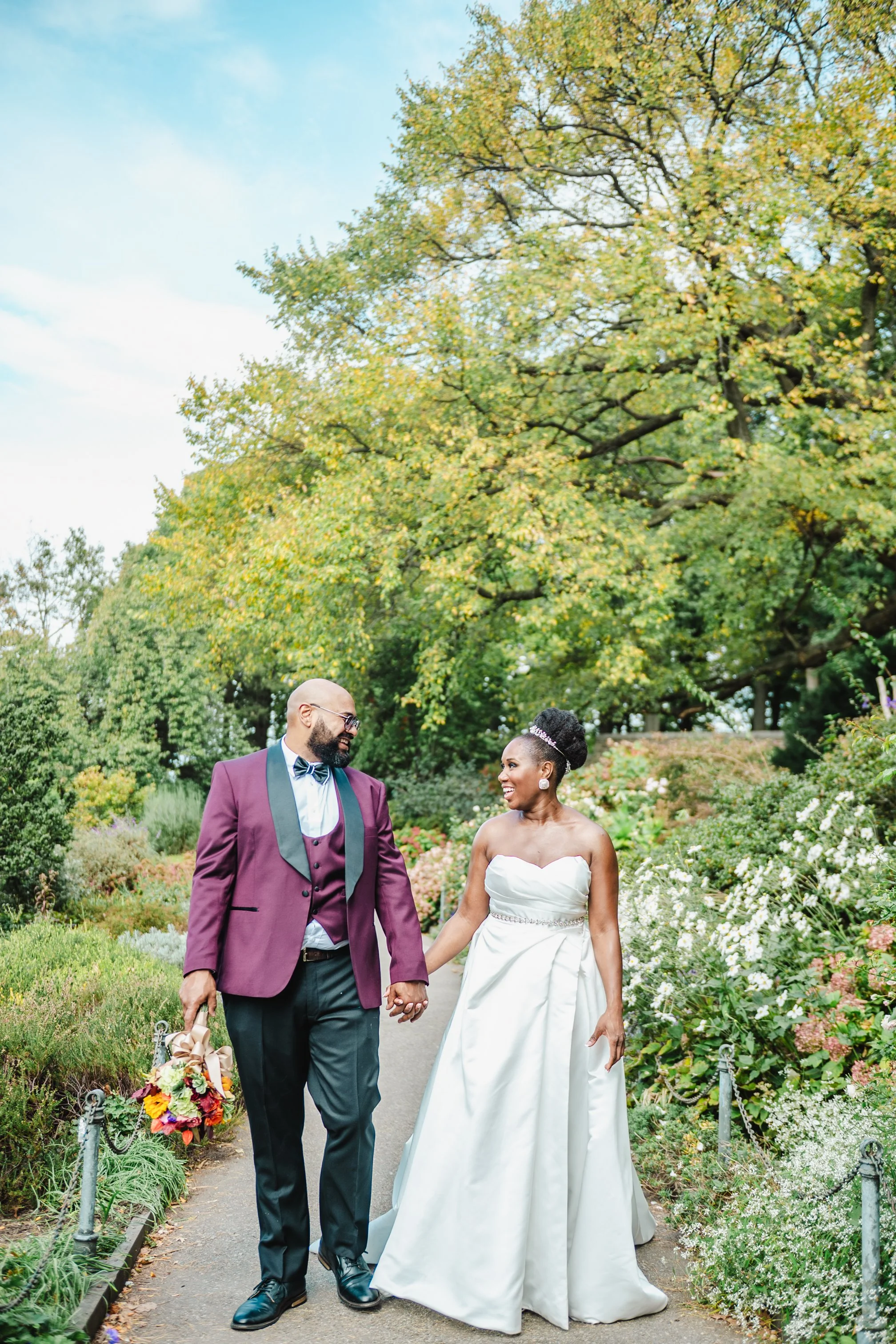 Brunette woman in white dress adjusting her hair in front of a mirror.