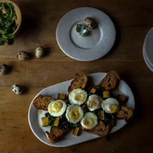 Quail Eggs with Wilted Arugula, Squash, and Toasted Baguette Rounds