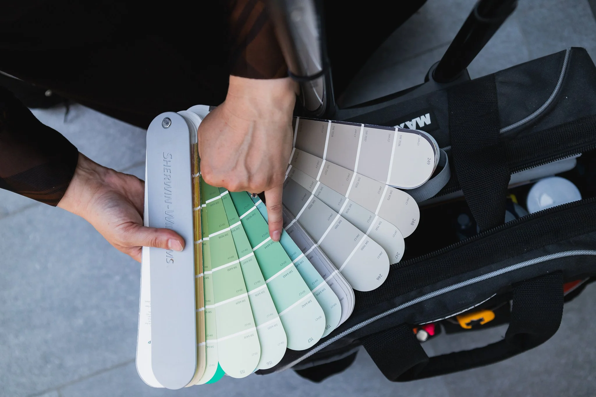 a girl points to a color selection on a fan deck as she is doing a home color consultation