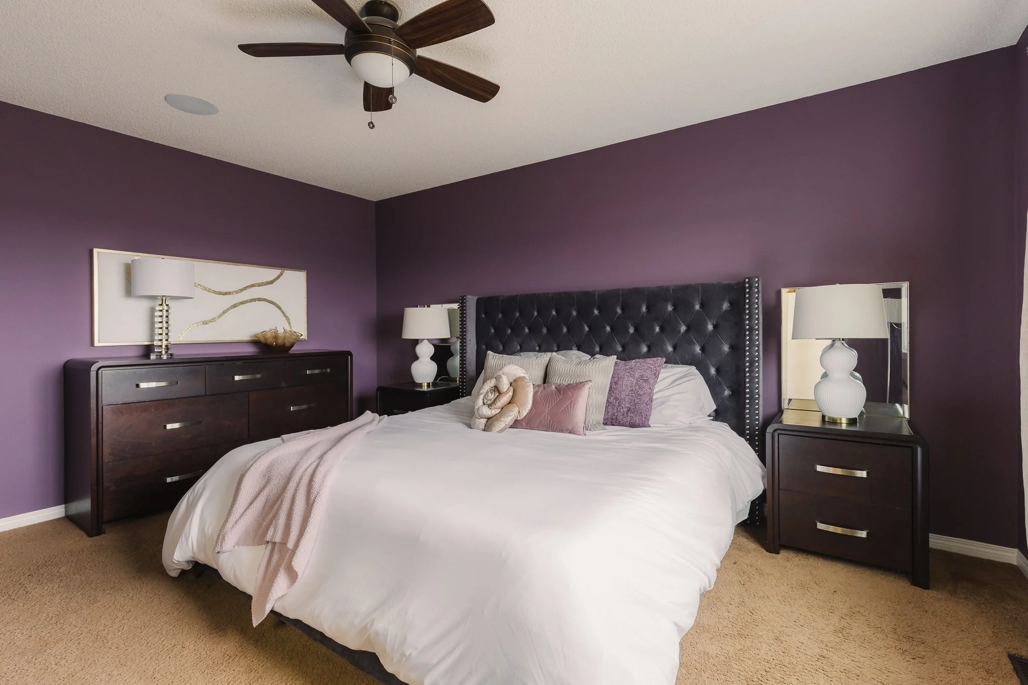 an elegant bedroom is shown with purple walls and white and gold accents